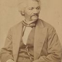 An old photographic, sepia-tone portrait of an African American man with white hair in a suit